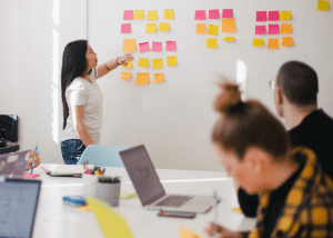 Woman putting sticky notes on wall during meeting