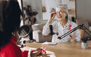 Two female radio hosts are recording a podcast episode in a professional studio,