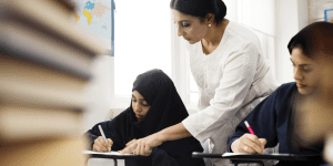 Teacher helping a student in class - CAF America Helps Charities in the Middle East Access Much-Needed Funding, Despite Complex Restrictions
