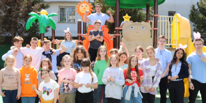 Ukrainian children standing in front of a playground smiling - Welcoming Ukrainian Refugees in Bulgaria