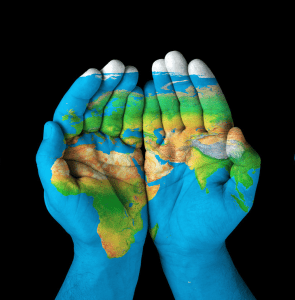 World Map painted on three sets on hands - Philanthropy done well the importance of compliance